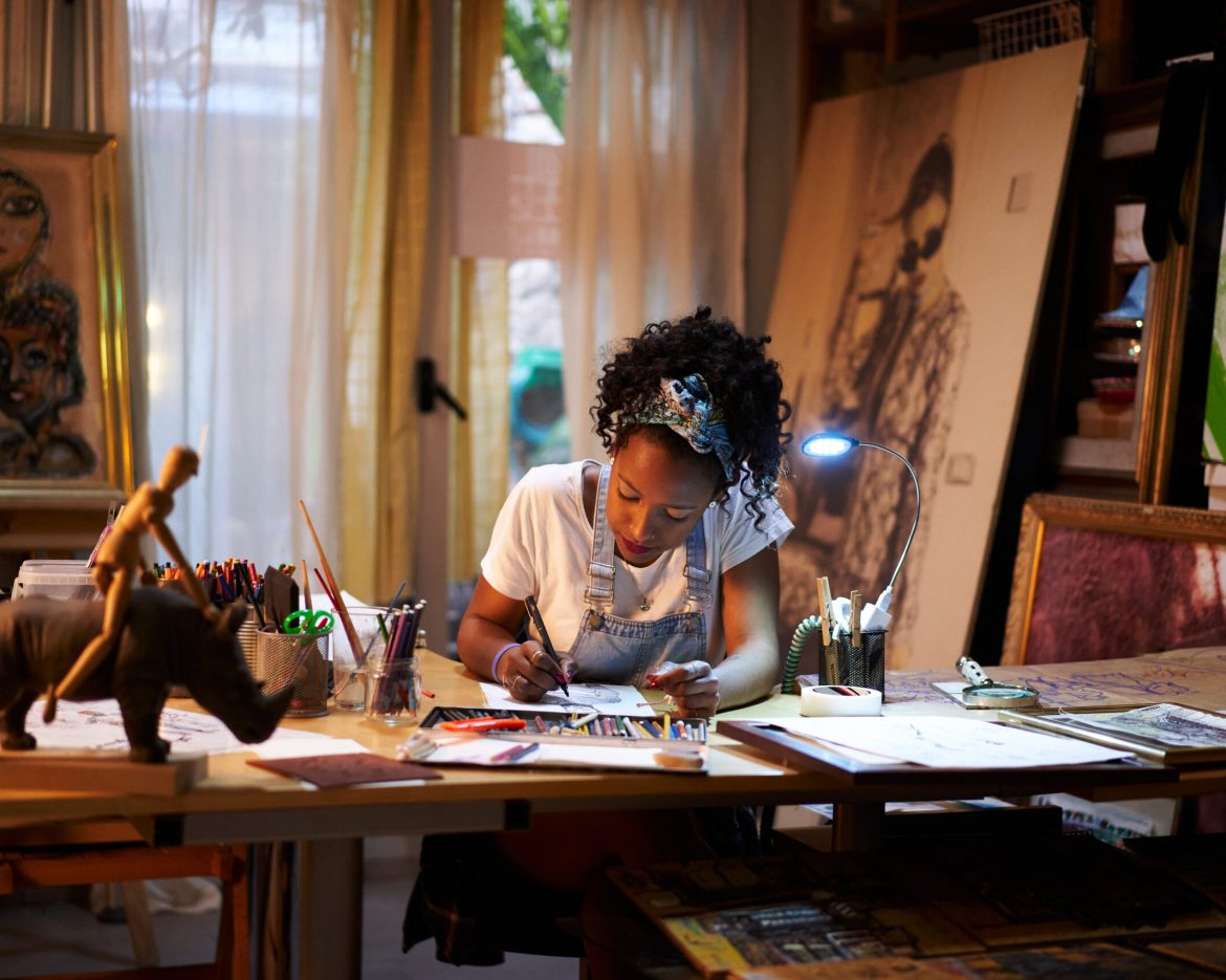 Young African-American artist at work in the studio. Creative person making art.